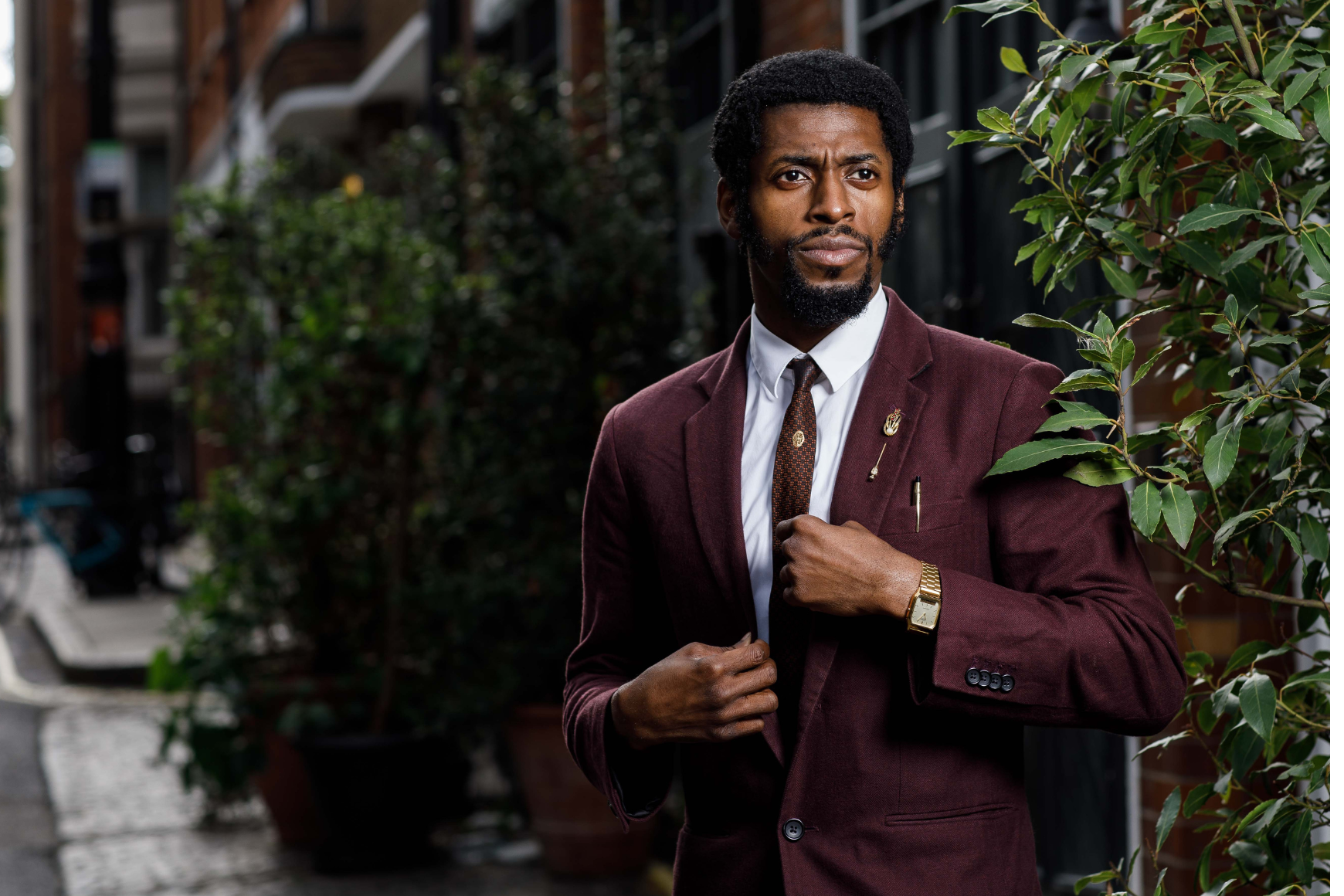 Image of Performer, The Odds dressed in burgundy suite near plants outdoors